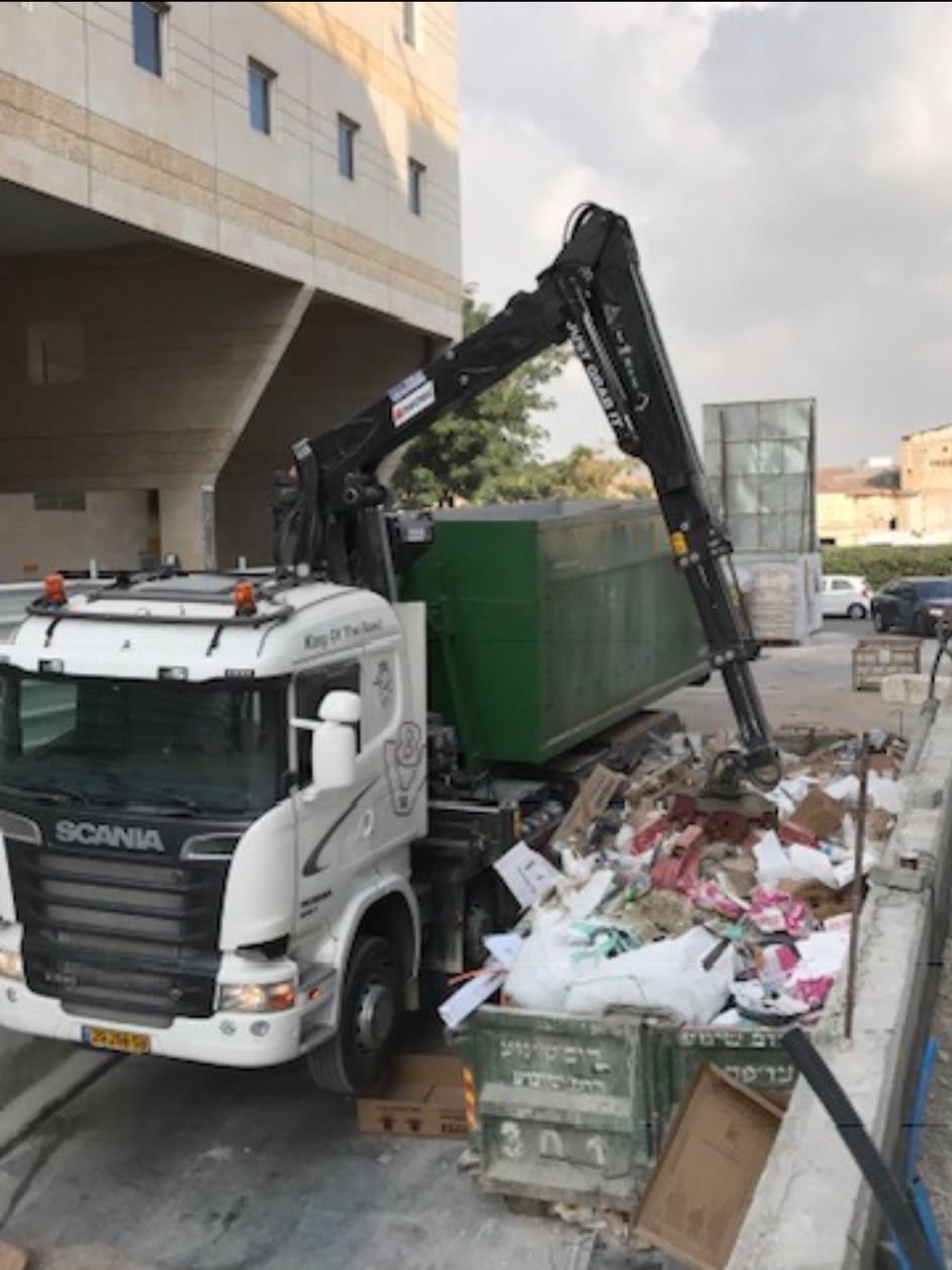 משאית מנוף מעמיסה פסולת בניין